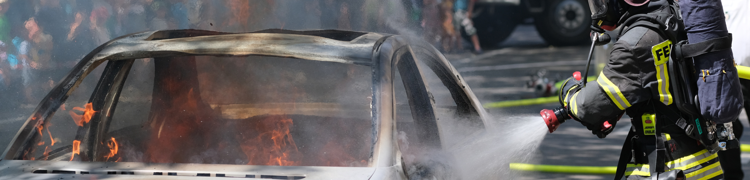 Feuerwehrmann löscht ein brennendes Auto